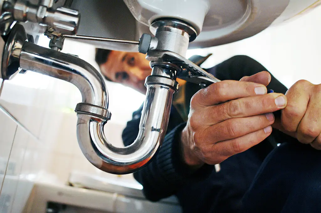 Plumber under a bathroom sink